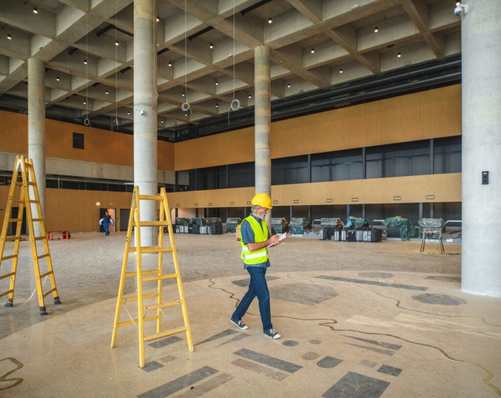 Construction worker inspecting large indoor space