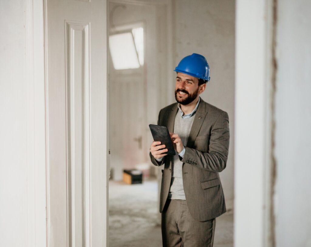 Man in suit and hard hat smiling