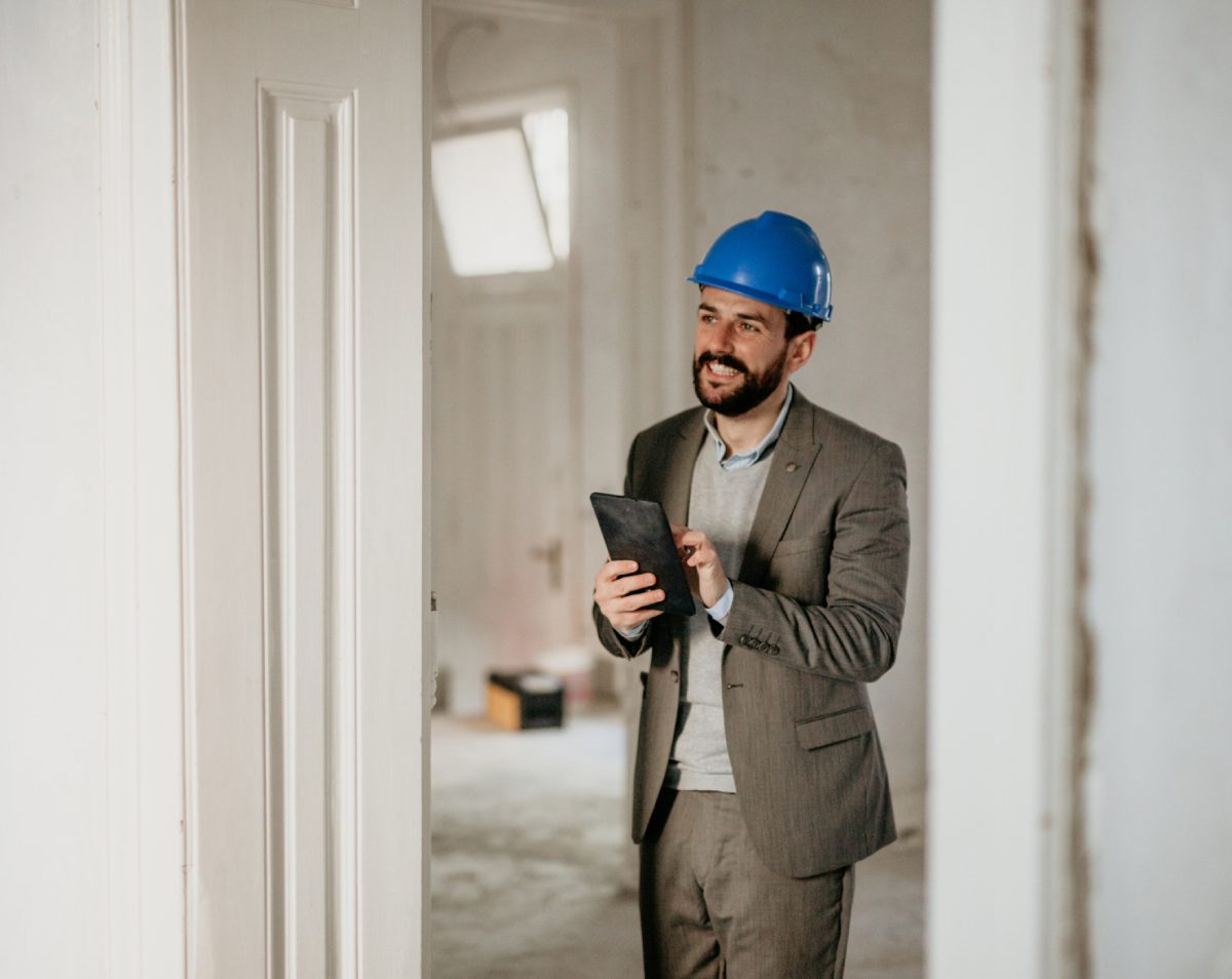 Man in suit and hard hat smiling