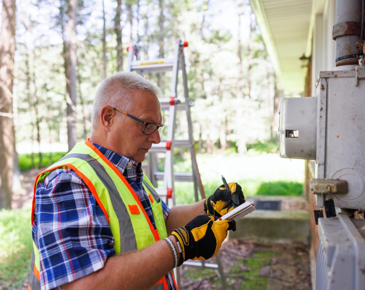 Worker inspecting outdoor electrical meter
