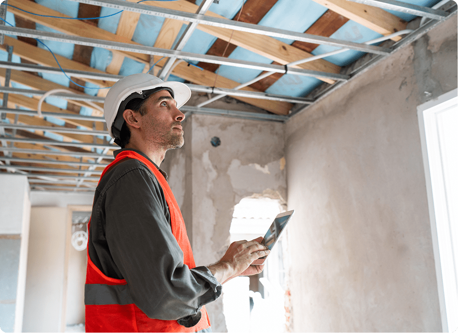 Builder checking renovation progress indoors